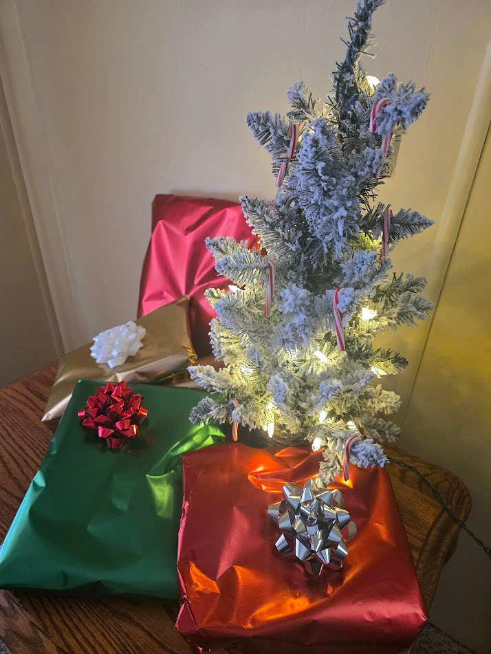 A small two foot tall flocked light up Christmas tree decorated with red and white candy canes.